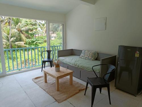 a living room with a couch and two chairs and a table at Beseco Bed and Breakfast in Benaulim