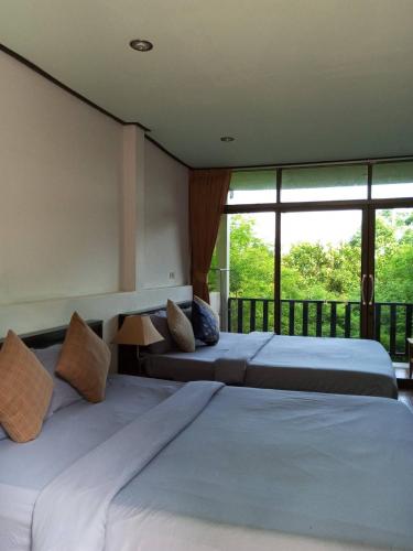 two beds in a room with a balcony at Faye Orchid Garden Resort in Ko Chang