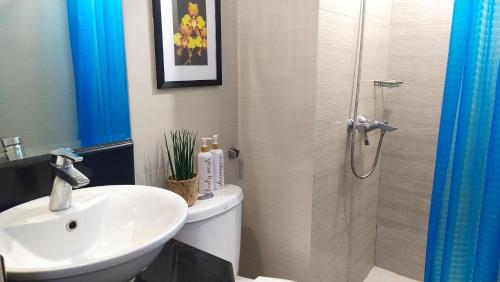 a bathroom with a toilet and a sink and a shower at 150 Newport Boulevard Near NAIA Terminal 3 in Manila