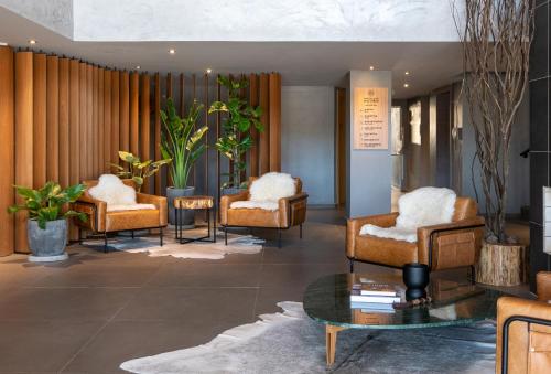 a lobby with a group of chairs and a table at Jangal das Araucárias Swan Design Hotel Canela in Canela