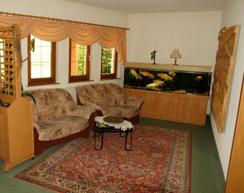 a living room with a couch and a fish tank at Hotel & Restaurant Danelchristelgut in Lauter
