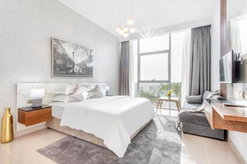 1 dormitorio blanco con 1 cama grande y 1 sofá en Live and experience an island life - 2BR Apartment en Ras al-Khaimah