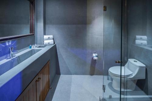 a bathroom with a toilet and a glass shower at Hotel Parque España in Mexico City