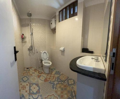 uma casa de banho com um lavatório e um WC em Radja House Cipaku Indah em Bandung