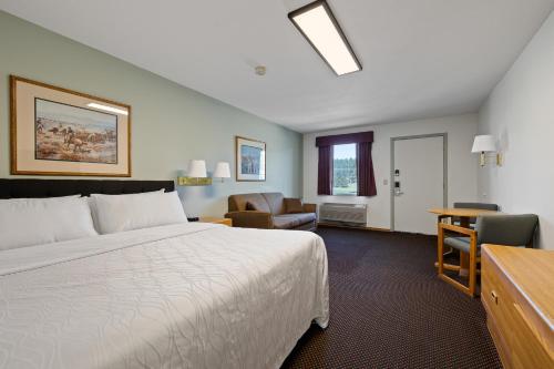 a hotel room with a bed and a chair and a desk at The Ponderosa in Custer