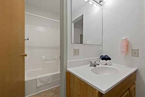 a white bathroom with a sink and a mirror at The Ponderosa in Custer