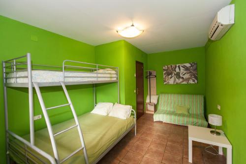 um quarto com 2 beliches num quarto verde em Camping Riba-roja em Riba-roja d'Ebre