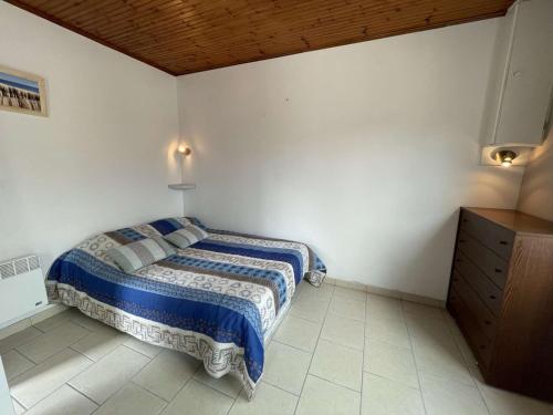 une chambre avec un lit et un plafond en bois dans l'établissement Charmante maison à Saint-Jean-de-Monts, 400m de la plage, terrasse, jardin, parking et ménage inclus - FR-1-224C-198, à Saint-Jean-de-Monts