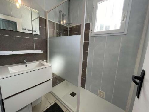 une salle de bain avec un lavabo et un miroir dans l'établissement Charmante maison à Saint-Jean-de-Monts, 400m de la plage, terrasse, jardin, parking et ménage inclus - FR-1-224C-198, à Saint-Jean-de-Monts