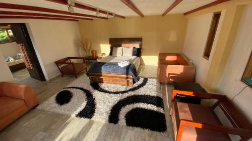 a bedroom with a bed and a rug on the floor at Cabaña Piedra&Cielo in Guatavita