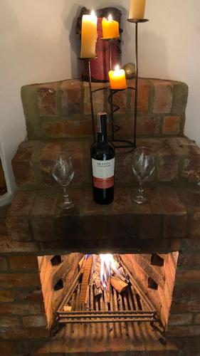 a bottle of wine sitting on a table with two glasses at Cabaña Piedra&Cielo in Guatavita