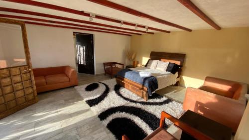 a bedroom with a bed and a couch and a rug at Cabaña Piedra&Cielo in Guatavita