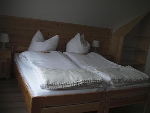 a bed with white sheets and pillows on it at Willa Grywałd in Grywałd