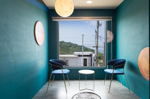 a room with blue walls and chairs and a window at Twenty Eight B&B in Xiaoliuqiu
