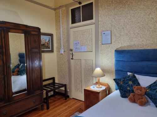 ein Schlafzimmer mit einem Bett mit einem Teddybär drauf in der Unterkunft Mountain View Country Inn in Lady Grey