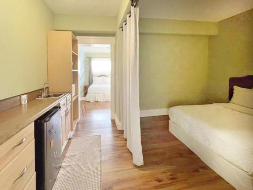 a kitchen with a bed and a sink in a room at Sunny Motel Port Elgin in Port Elgin
