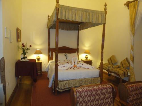a bedroom with a canopy bed and a chair at Hotel Midori in Cusco