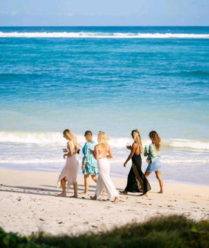 a group of women walking on the beach at Surya Lombok Accommodation in Selong Belanak