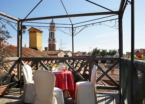 a dining room table with chairs and umbrellas at Hotel Ca' D'Oro in Venice