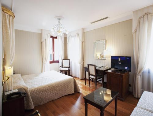a hotel room with a bed and a desk at Hotel Ca' D'Oro - WENICE Deep Culture in Venice
