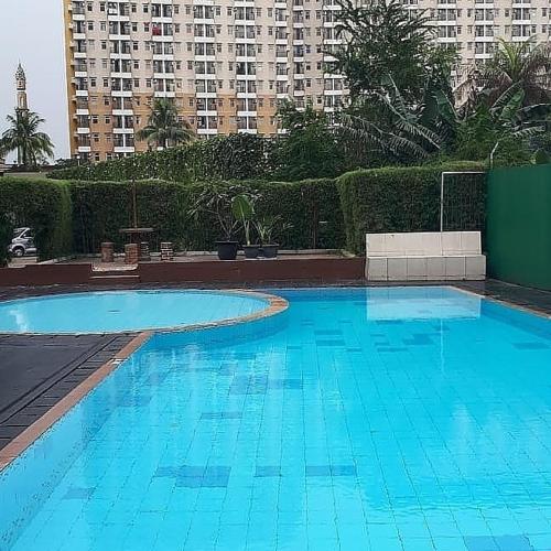 una grande piscina blu con edifici sullo sfondo di Apartemen margonda residence2 a Pondoktjina 1