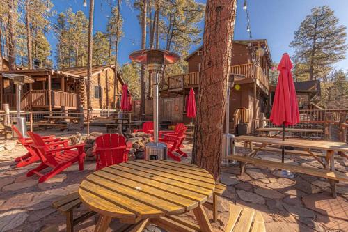 a picnic table and chairs in front of a log cabin at Forest Cabin 6 Enchanted Forest in Payson