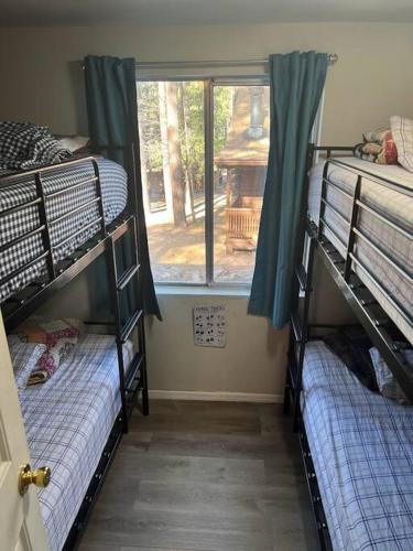 two bunk beds in a room with a window at Forest Cabin 7 Seventh Heaven in Payson