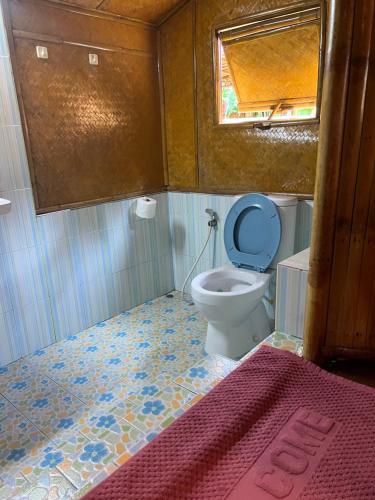 a bathroom with a toilet with a blue lid at Coco Sunset Beach in Ban Bang Po