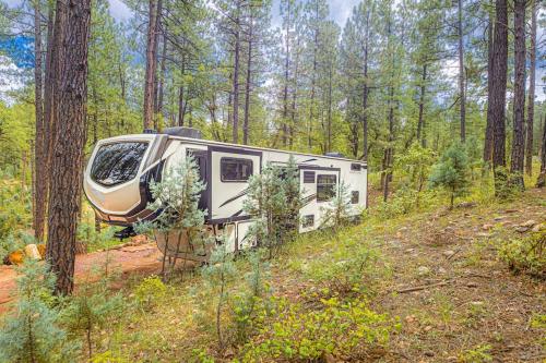 a camper parked in the woods on a dirt road at Luxury Glamper Retreat 14 Forest Site in Payson