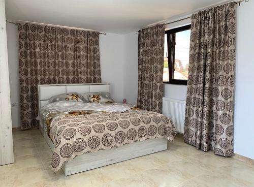 a bedroom with a bed with curtains and a window at Entire Home in Bucharest
