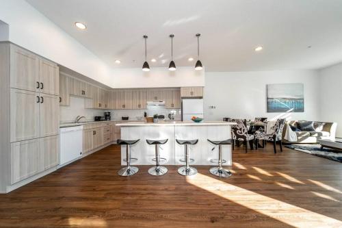 a kitchen with wooden cabinets and a kitchen island with bar stools at Stylish Close to D/T FREE parking King Bed 2bed in Edmonton