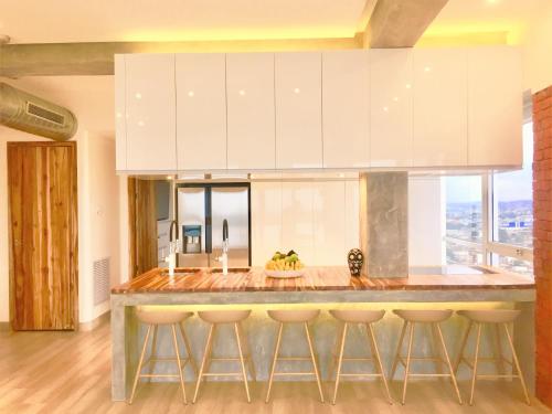 a kitchen with a large island with bar stools at Luxury Apartment Heart Of Guayaquil in Guayaquil