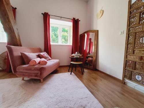 a living room with a chair and a window at Les Tilleuls de Marie in Saint-Edmond