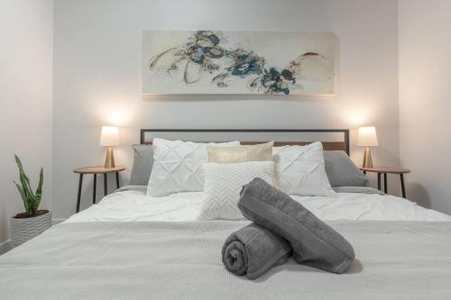a bedroom with a white bed with towels on it at Chic Romantic3bed patio WIFI quiet retreat parking in Calgary