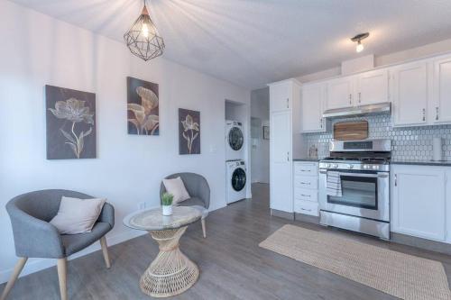 a kitchen with white cabinets and a table and chairs at Chic Romantic3bed patio WIFI quiet retreat parking in Calgary