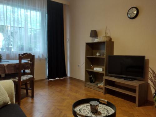 a living room with a television and a table at Прекрасен апартамент в Бургас in Burgas