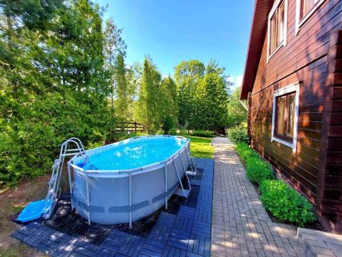 a large bath tub sitting next to a house at Sodyba Vilagio in Alanta