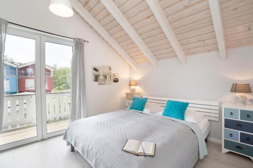 ein Schlafzimmer mit einem Bett und einem großen Fenster in der Unterkunft Seepark Süssau Ferienhaus Seehund 4 in Süssau