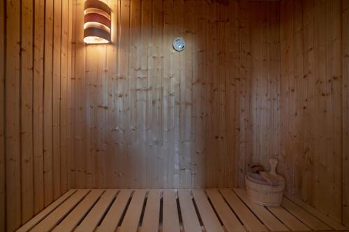 ein Zimmer mit einer Holzwand mit einer Uhr und einem Eimer in der Unterkunft Seepark Süssau Ferienhaus Seehund 4 in Süssau