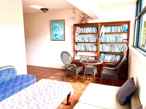 a living room with a table and chairs and bookshelves at 溪頭18號 in Lugu