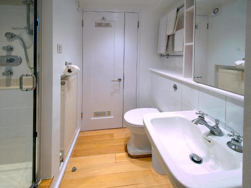 a white bathroom with a toilet and a sink at Please do not book in London