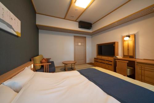 a hotel room with a bed and a television at Kyoto Umekoji Kadensho in Kyoto