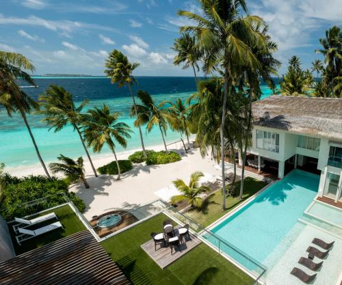an aerial view of a resort with a swimming pool and the ocean at Amilla Maldives in Kihaadhoo