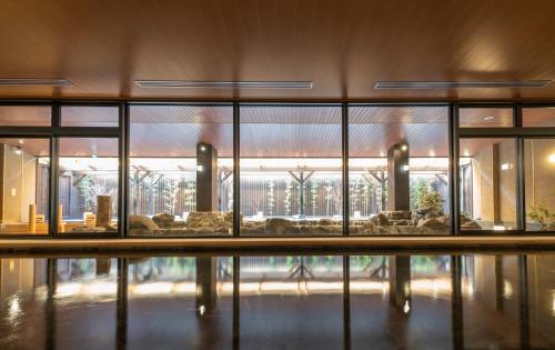 a building with a reflection in a pool of water at Kyoto Umekoji Kadensho in Kyoto