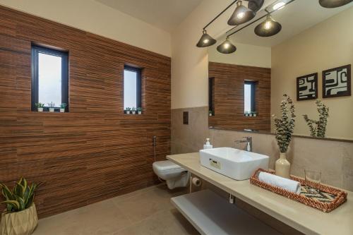 a bathroom with a sink and a toilet at SaffronStays Yahvi Waters by Kosha Villas, Pawna - pool villa with stunning lake view in Lonavala