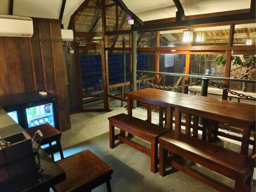 a dining room with wooden tables and a tv at Niyati - Boutique Stay in Cochin
