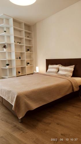 una camera da letto con un grande letto con scaffali bianchi di HaPPy Inn Egle, Self Check-In-24-7, A-C, Parking-in-the-underground-Garage a Vilnius