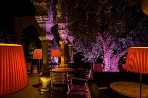 a room with tables and chairs and lamps at Palais Namaskar in Marrakech