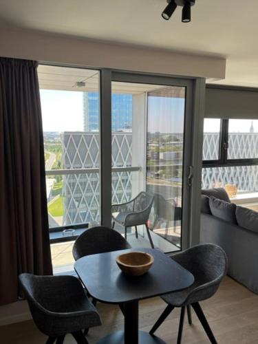 een woonkamer met een tafel en stoelen en een balkon bij "VH apartment" - center of Antwerp - free parking in Antwerpen