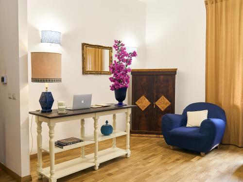Habitación con mesa, ordenador portátil y silla azul en Qurchiti, en Capo dʼOrlando